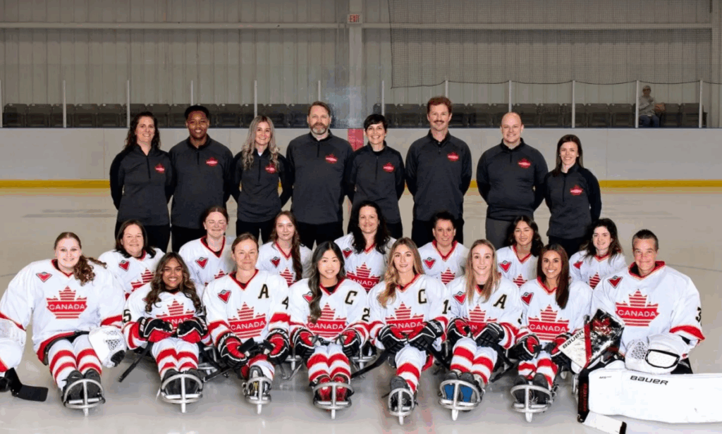 Team Canada players and coaches pose on the ice for a roster photo