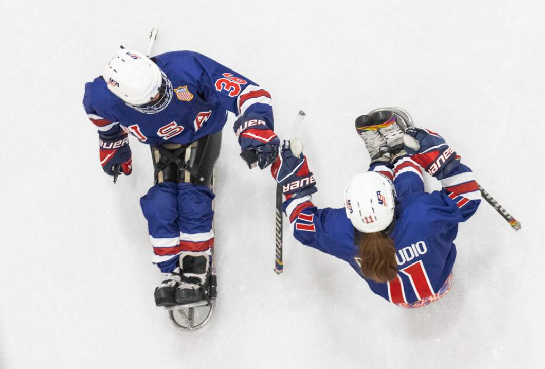 An aerial photo shows Kaden Herchenroether (left) and Kelsey DiClaudio bump gloves on the ice