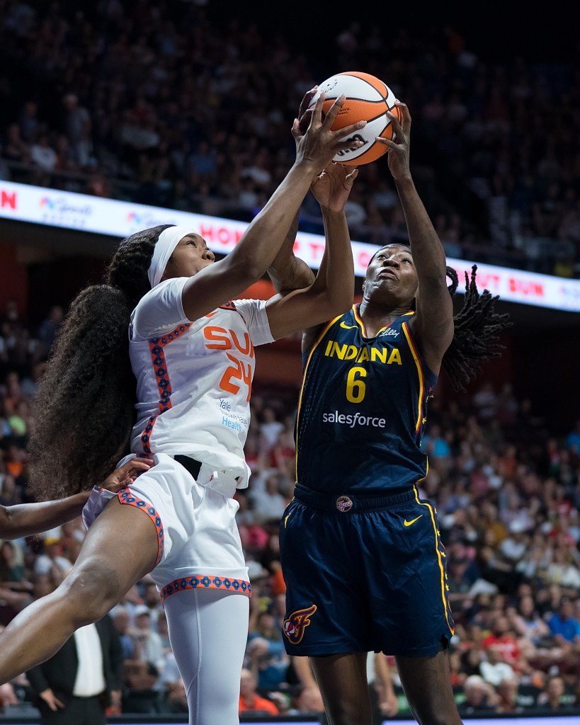 Aneesah Morrow jumps vertically in the air with her arms above her head to try and rebound the ball against Natasha Howard.