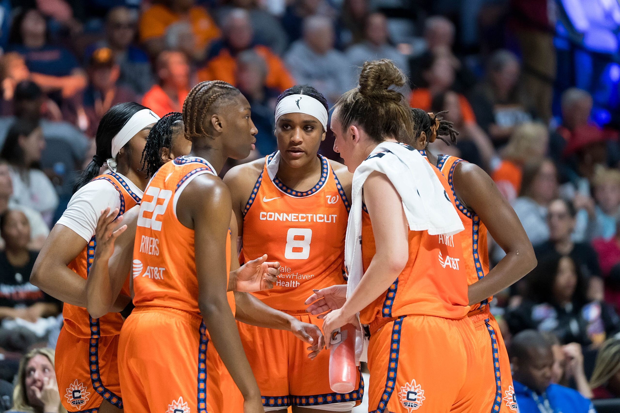 Connecticut Sun guard Saniya Rivers (22), Connecticut Sun guard Lindsay Allen (15), Connecticut Sun forward Aneesah Morrow (24), Connecticut Sun forward Aaliyah Edwards (8), Connecticut Sun center Tina Charles (31) and Connecticut Sun guard Marina Mabrey (3) huddle together with Edwards facing the camera.