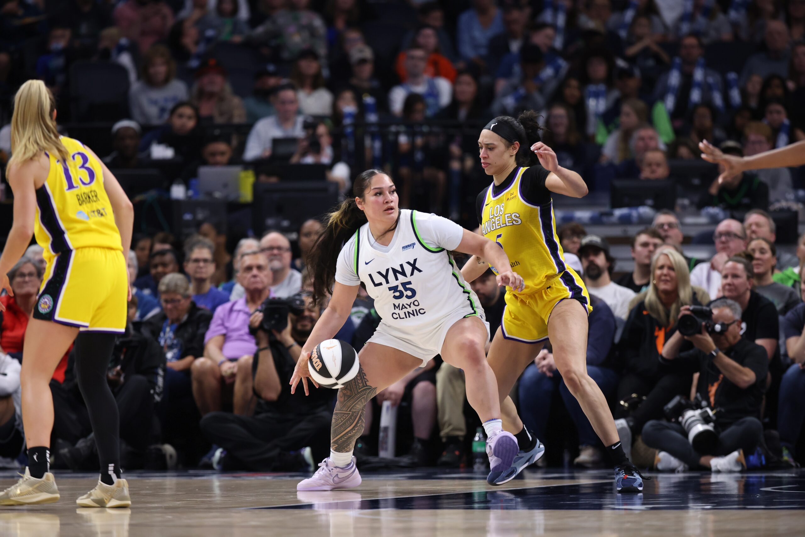 Alissa Pili backs down Dearica Hamby in front of a packed crowd that is blurred in the background.