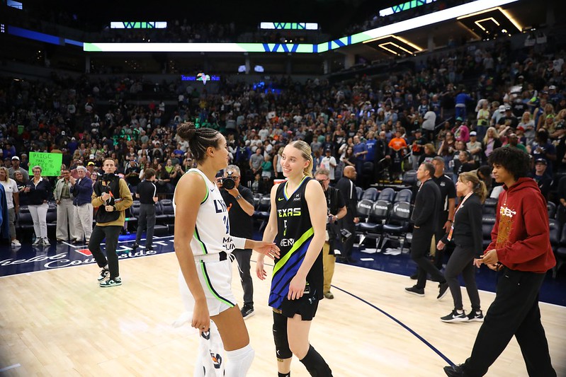 Napheesa Collier and Paige Bueckers chat on the court.