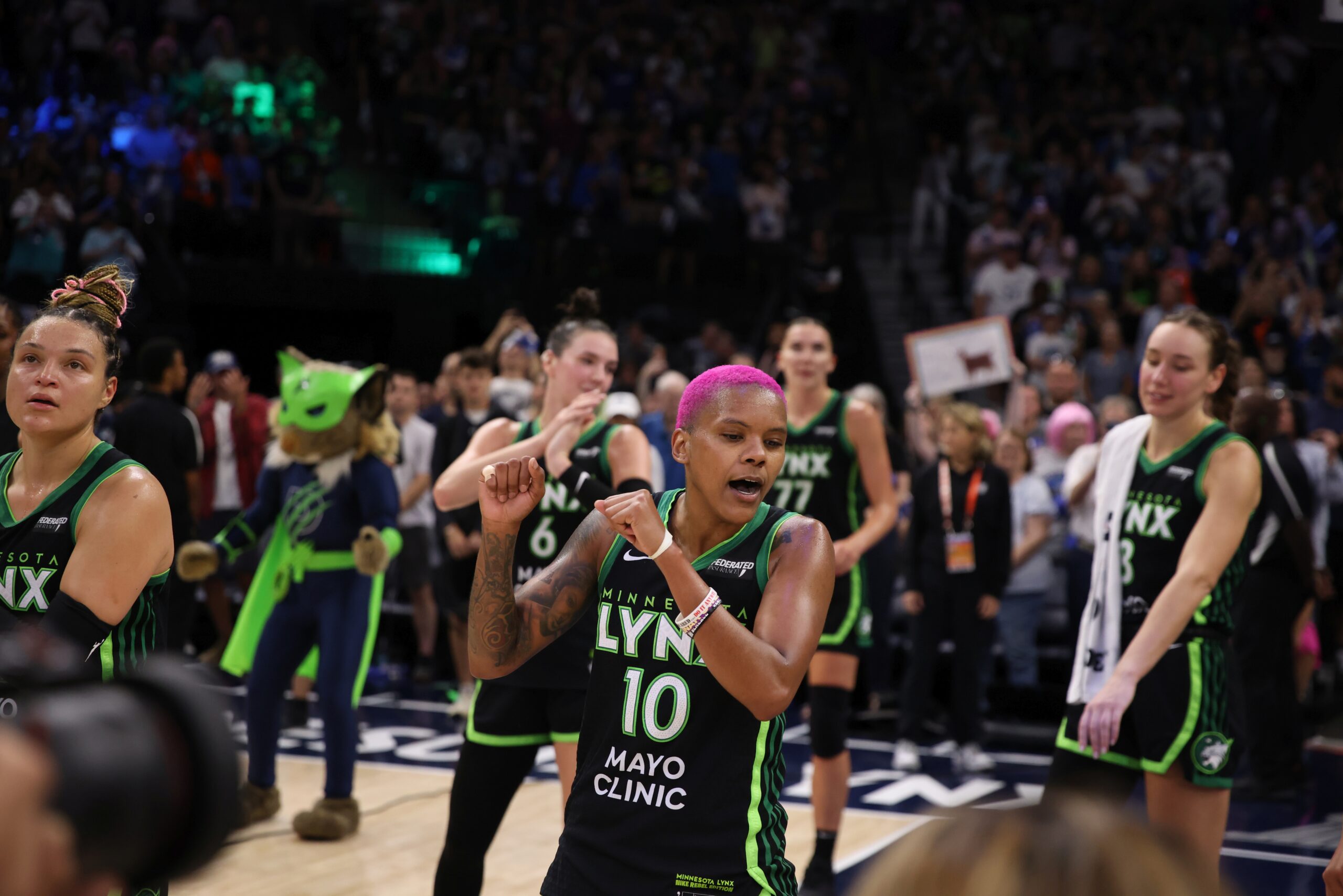 Courtney Williams dances in the Lynx's victory celebration in her black No. 10 jersey and pink hair