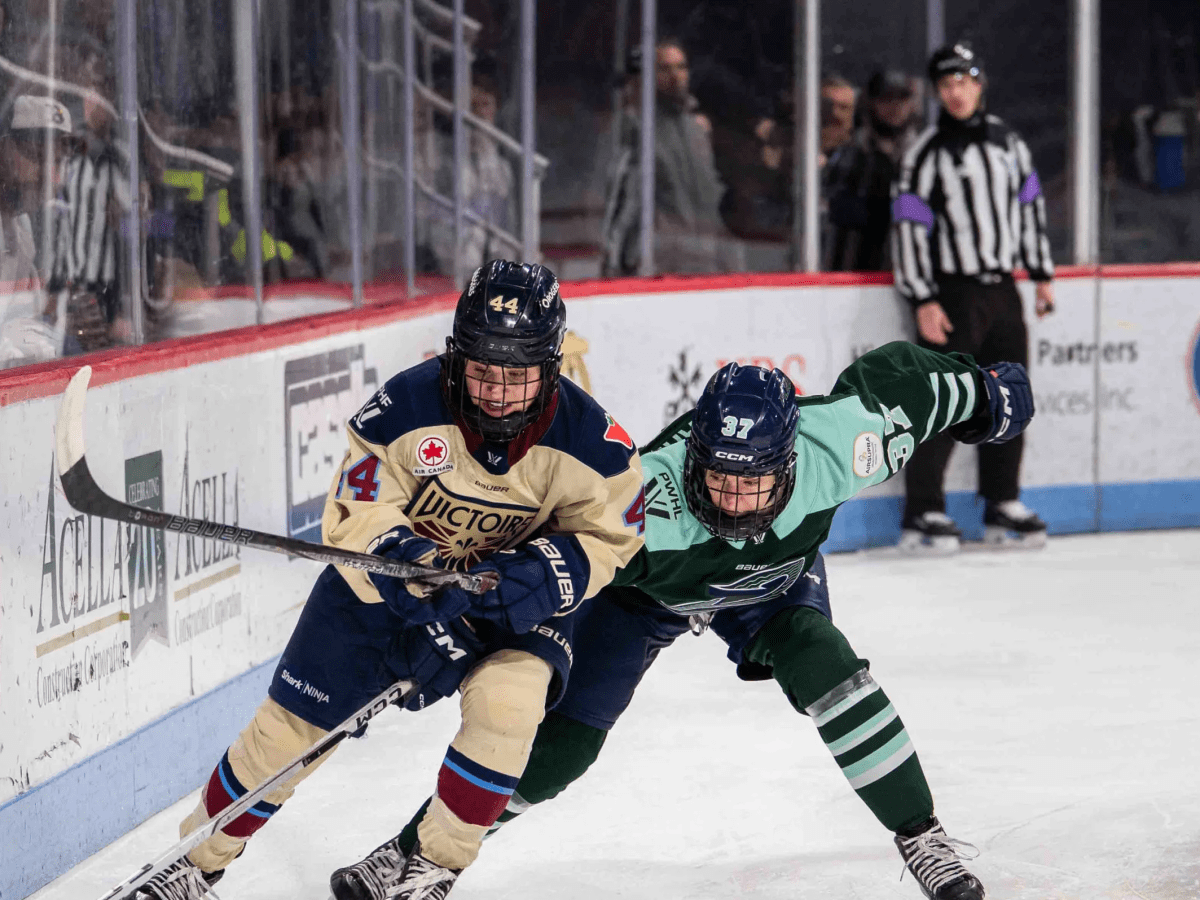Boston Fleet forward Theresa Schafzahl (right) gets her stick caught trying to retrieve the puck from Montréal Victoire defender Amanda Boulier.
