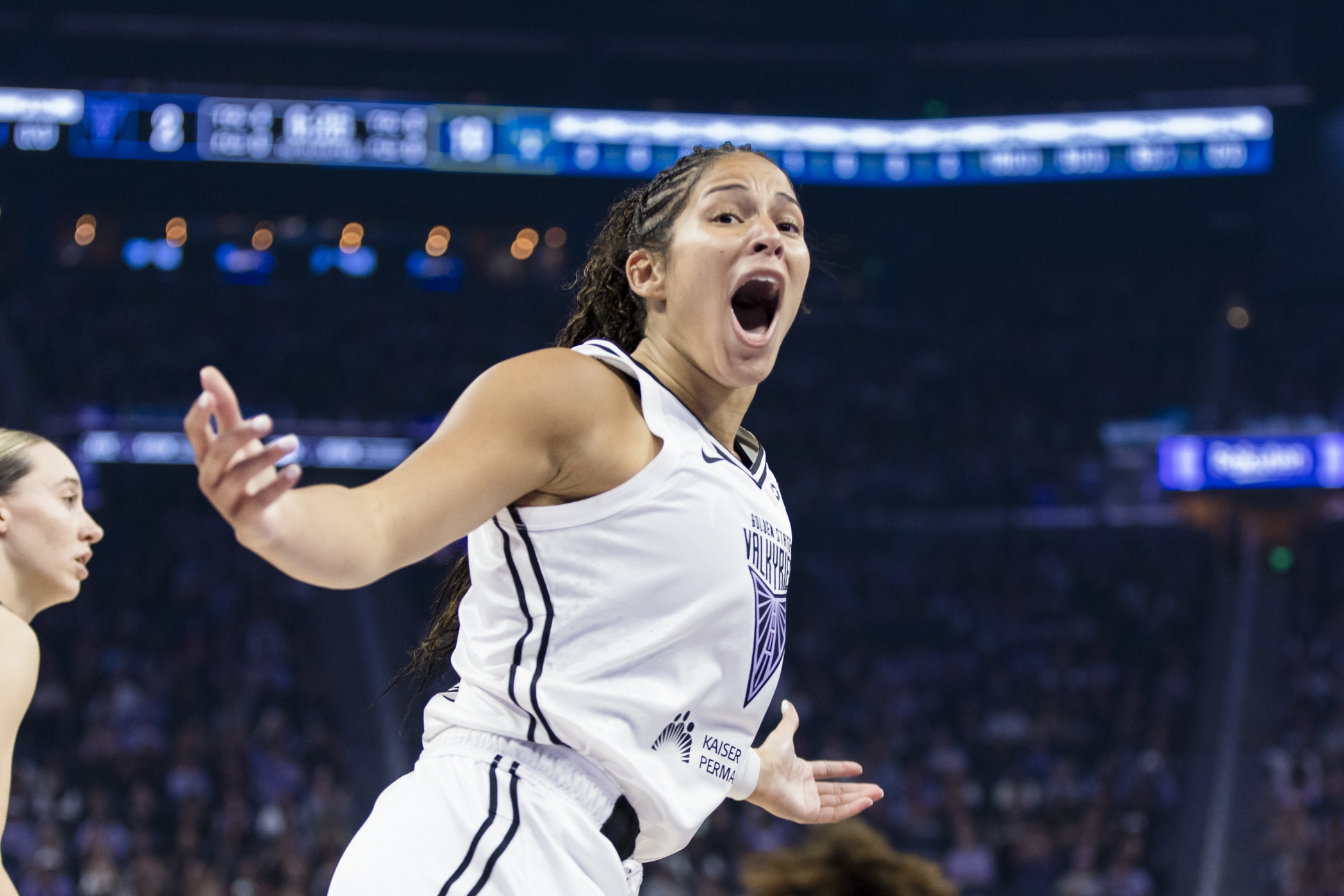 Golden State Valkyries guard Veronica Burton screams excitedly. Her arms are extended to the side, with both palms turned upward.