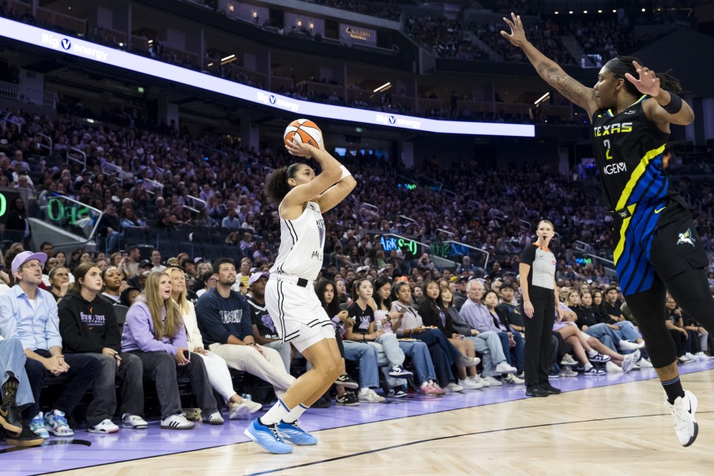 Golden State Valkyries forward Janelle Salaun takes a three-point shot. She is shown from from the side with a large crowd behind her.