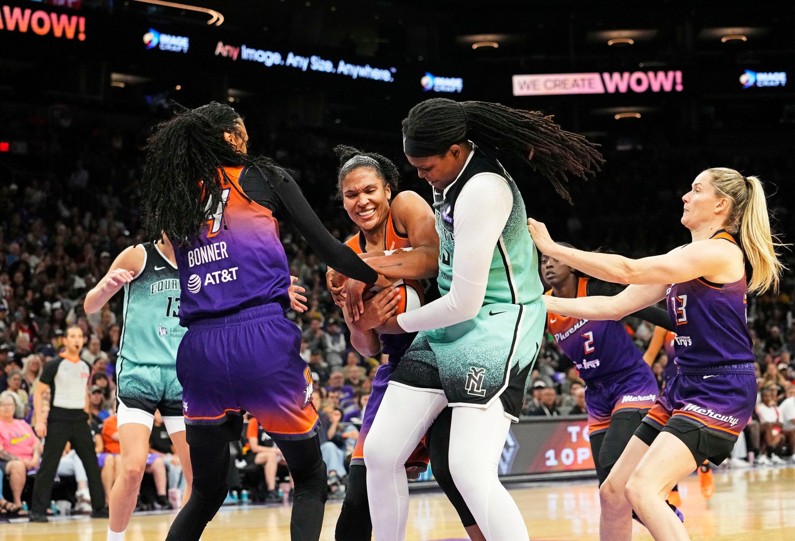 Jonquel Jones battles with Alyssa Thomas for the rebound with both players squeezing their hands on the ball.