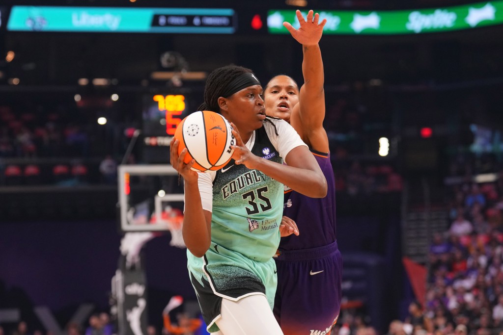New York Liberty center Jonquel Jones holds the ball close to her face as Phoenix Mercury forward Alyssa Thomas guards her tightly.