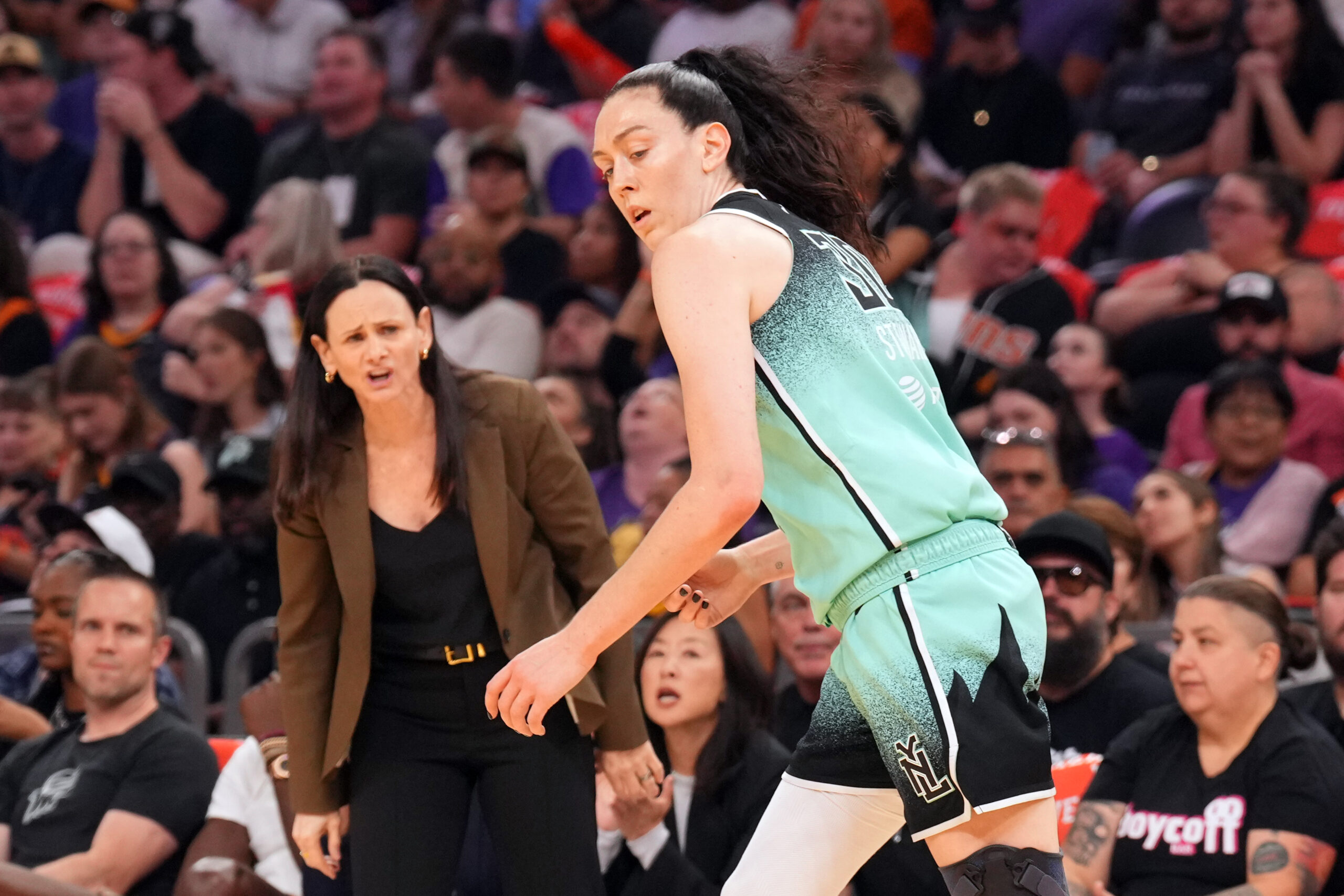 New York Liberty head coach Sandy Brondello shouts something as forward Breanna Stewart runs back on defense after making a shot.