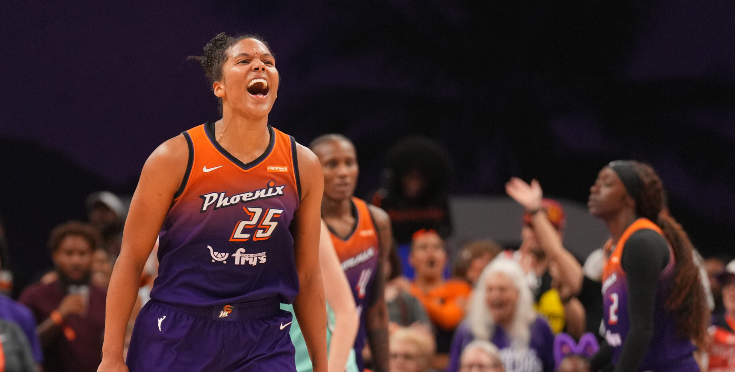 Alyssa Thomas faces the camera, hyped up about a recent play while a few of her teammates stand in the background