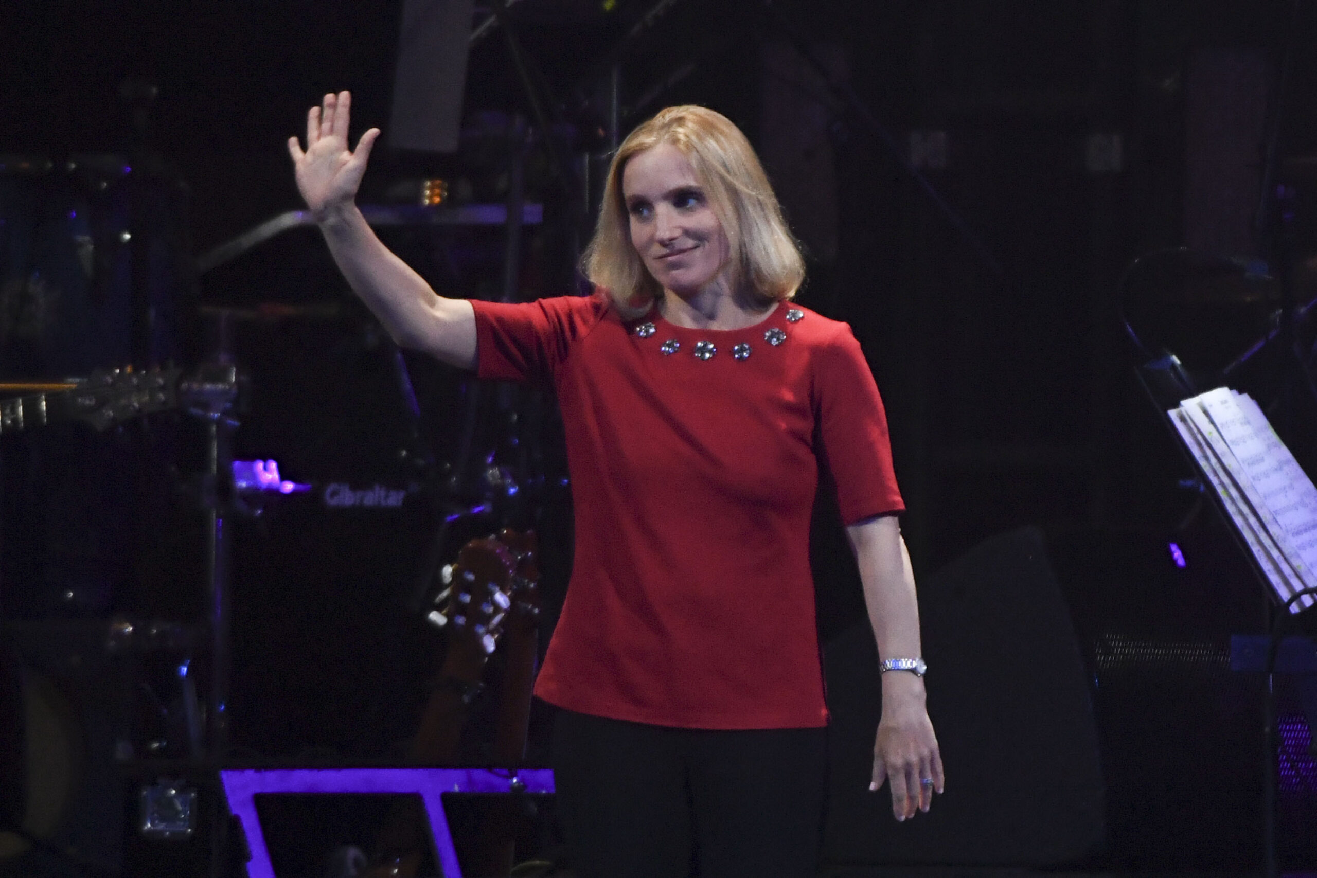 Kerri Strug waves her right hand to a crowd