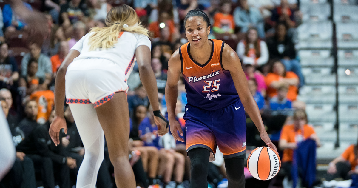 Alyssa Thomas looks forward and dribbles the ball. There is a defender in the foreground.