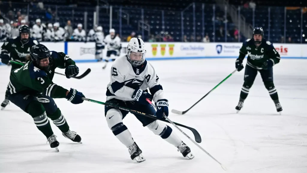 Women's college hockey player skates on the ice while her opponents surround her.