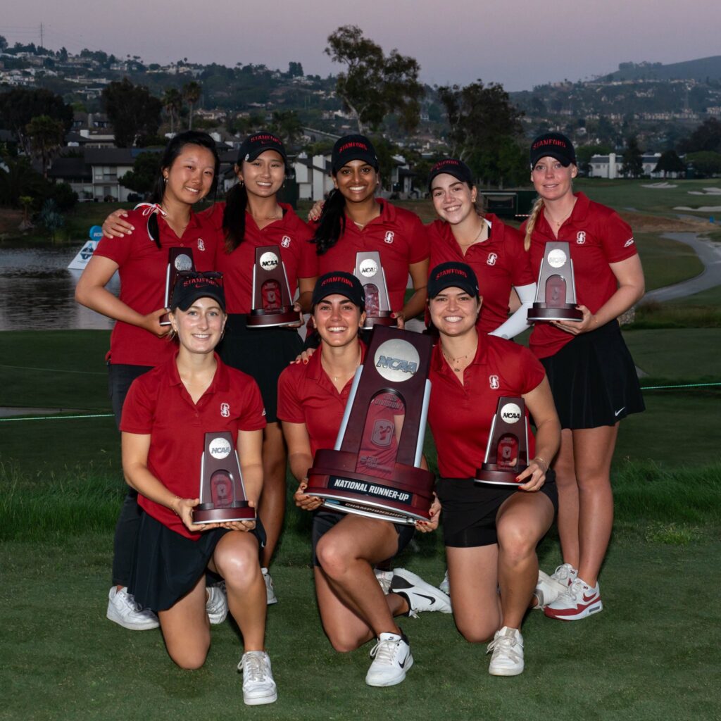 The Stanford women's golf team poses in a group with the National Championship Runners-Up trophy in the middle. Five players stand in the back row with their trophies in hand and three kneel in the front. The center player in the front holds the large team runners-up trophy.