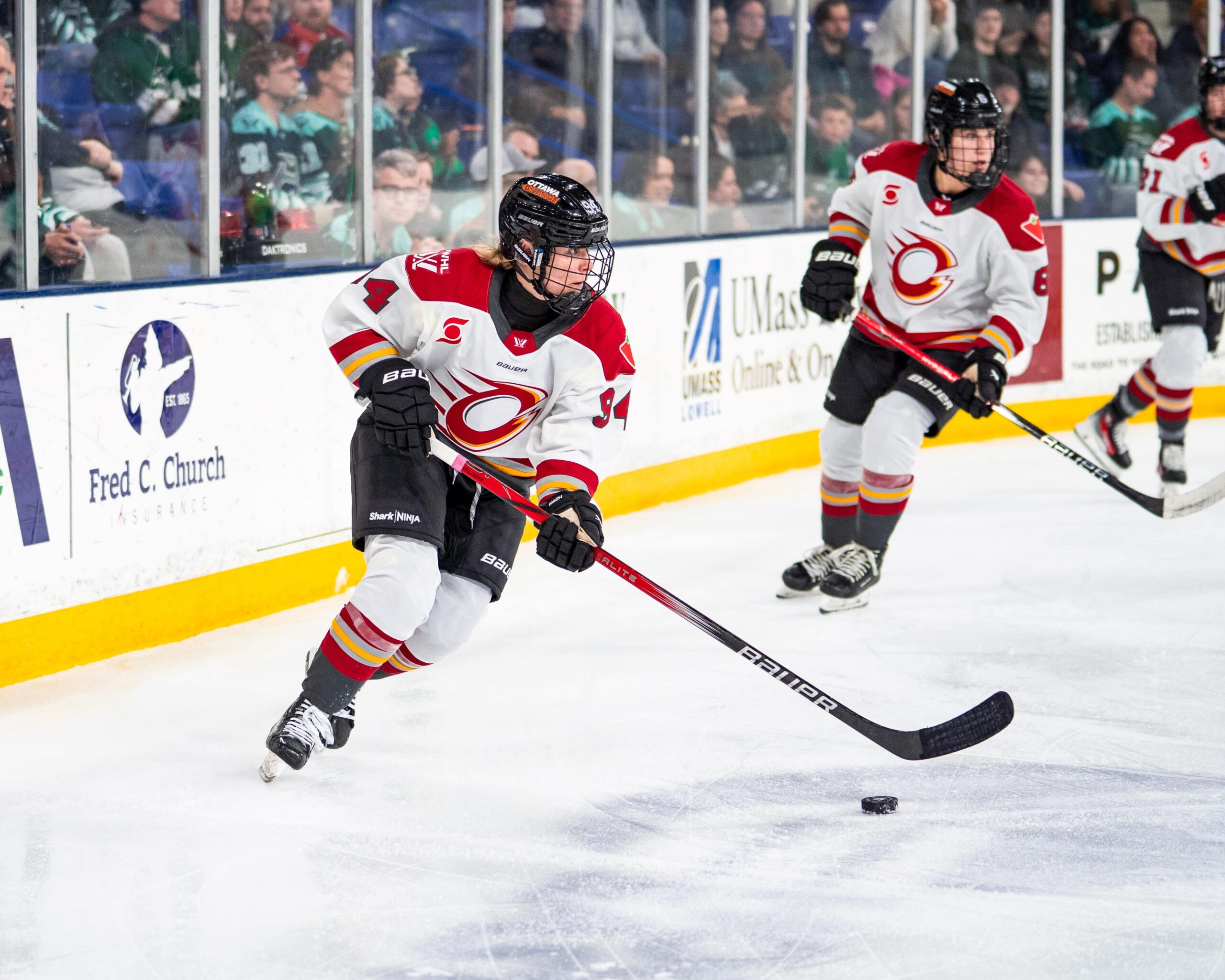 Anna Meixner, wearing a red and white Ottawa Charge jersey, handles the puck