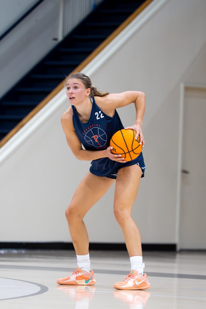 Pepperdine guard Lina Falk holds the ball at the top of the key. She is shown from the front.