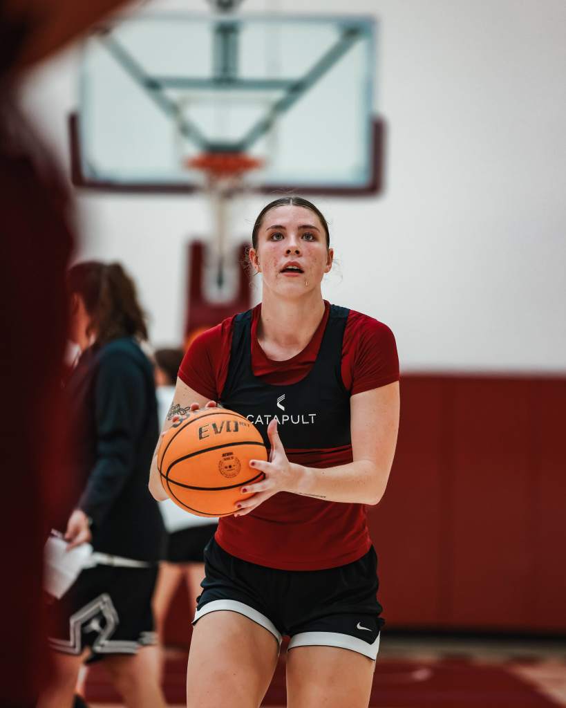 Santa Clara forward Sophie Glancey prepares to shoot the ball. She is shown from the front with an out of focus basket in the background.