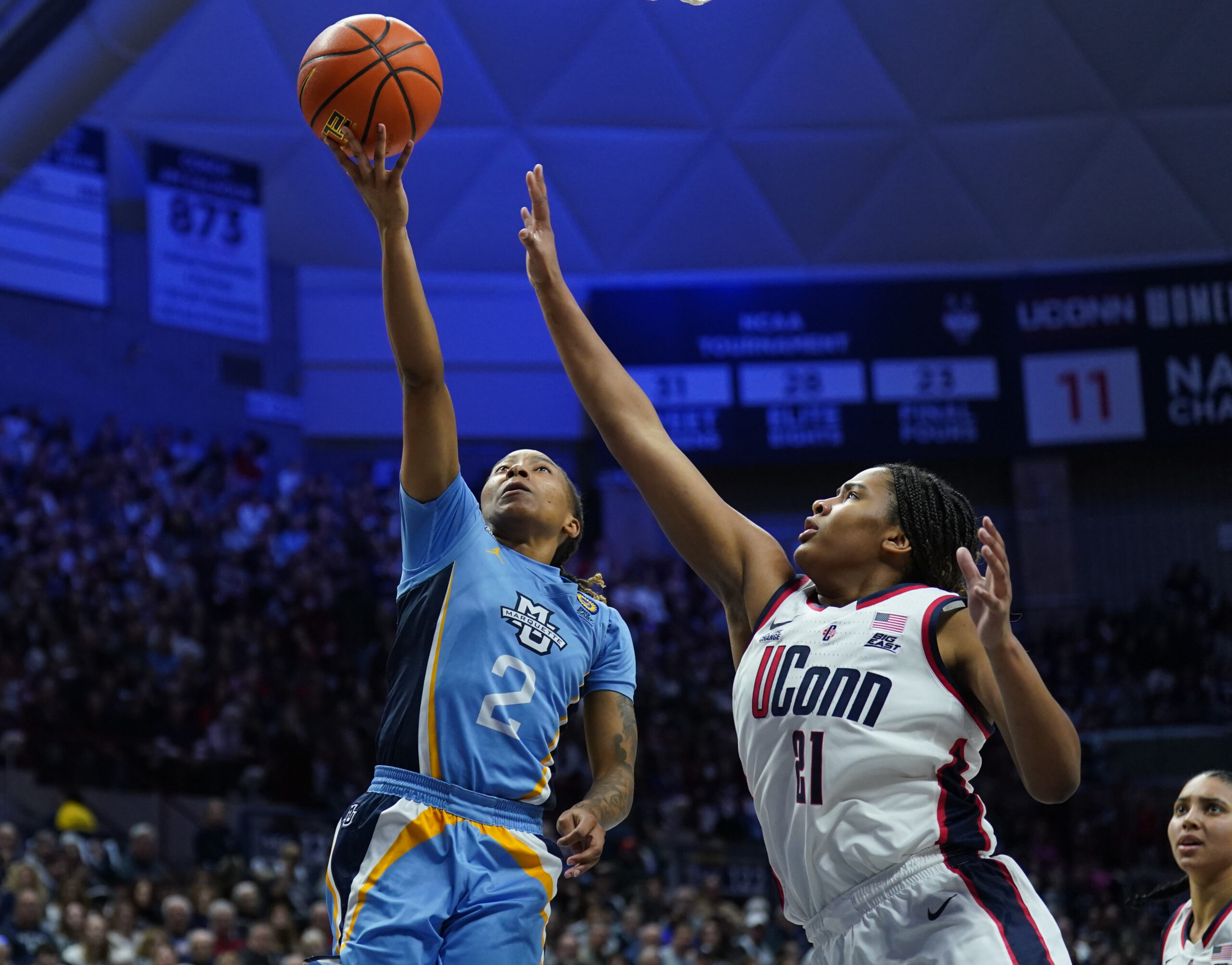 Marquette guard drives to the basket against UConn forward Sarah Strong