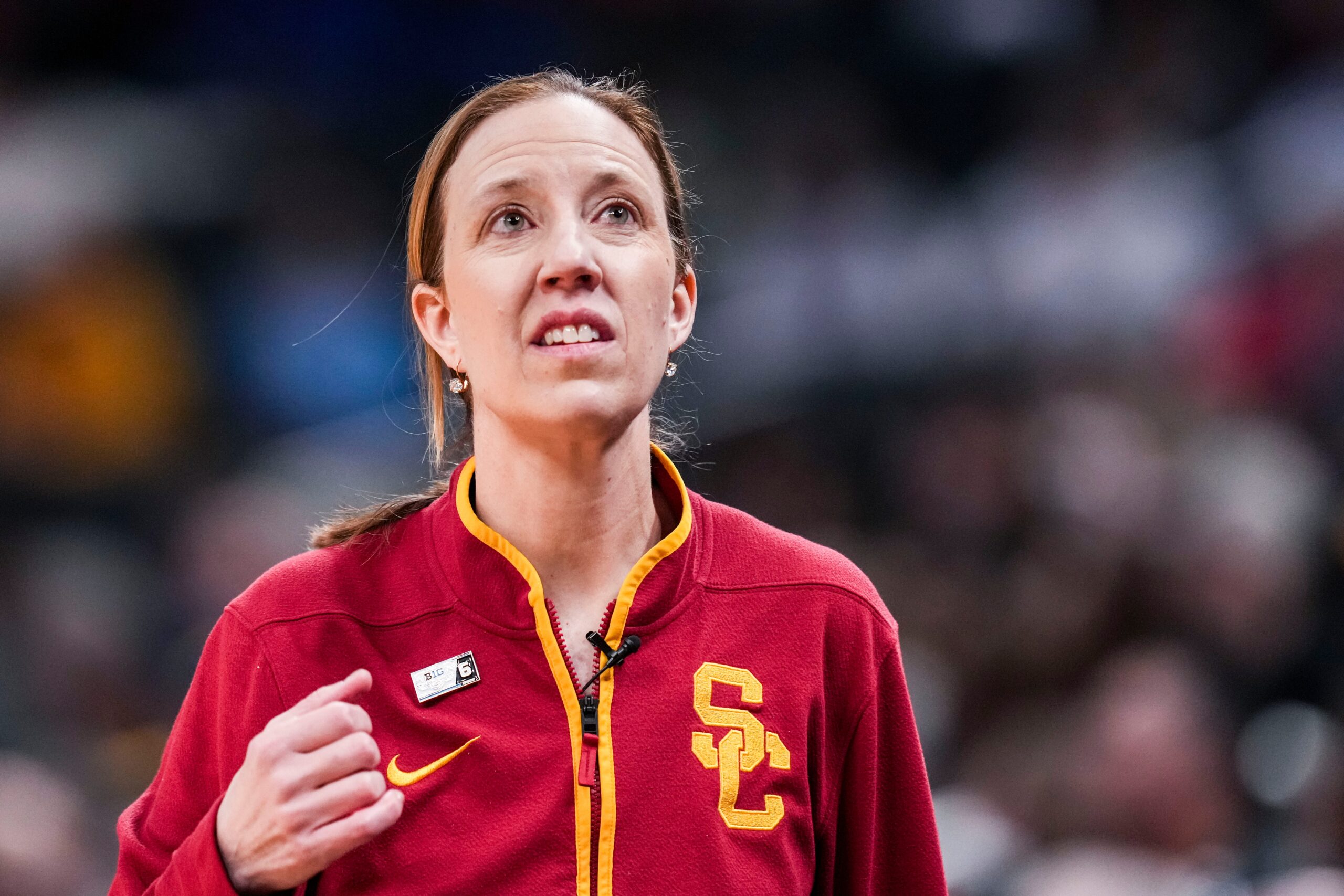USC Trojans women's basketball head coach Lindsay Gottlieb looking up, wearing a red USC zip up jacket.