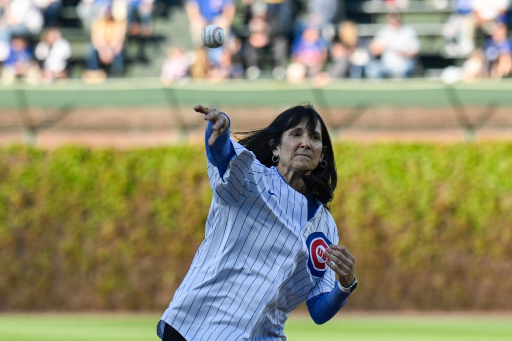 DePaul head coach Jill M. Pizzotti throws a baseball while weaing a Chicago Cubs jersey