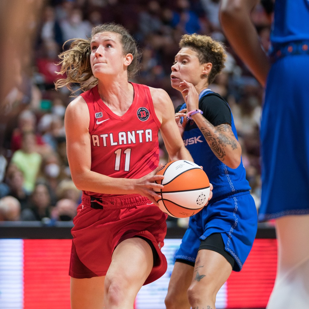 Atlanta Dream guard Blake Dietrick-Seifert holds the ball with two hands near her left hip. She has a step on Connecticut Sun guard Natisha Hiedeman as she attacks the basket.