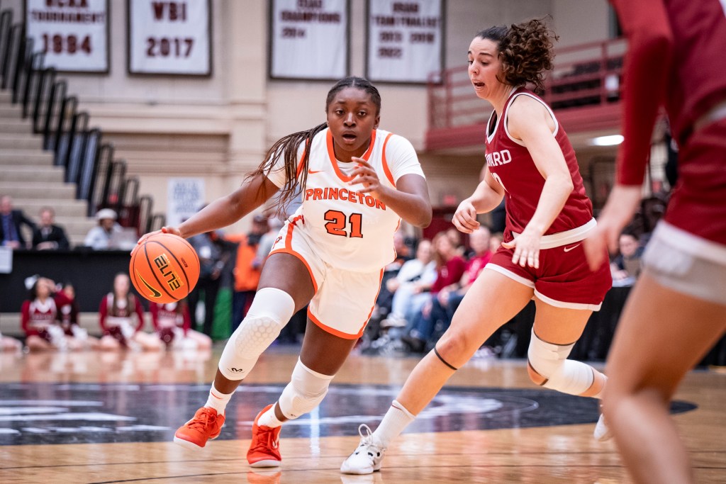 Princeton guard Toby Nweke dribbles the ball with her right hand. Harvard guard/forward Elena Rodriguez is on her left side and tries to stay in front of her.