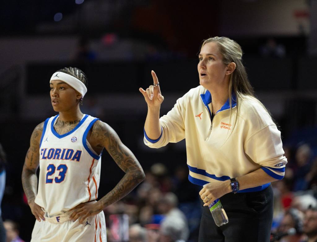 Florida's head coach and star guard discuss the next play during a game.