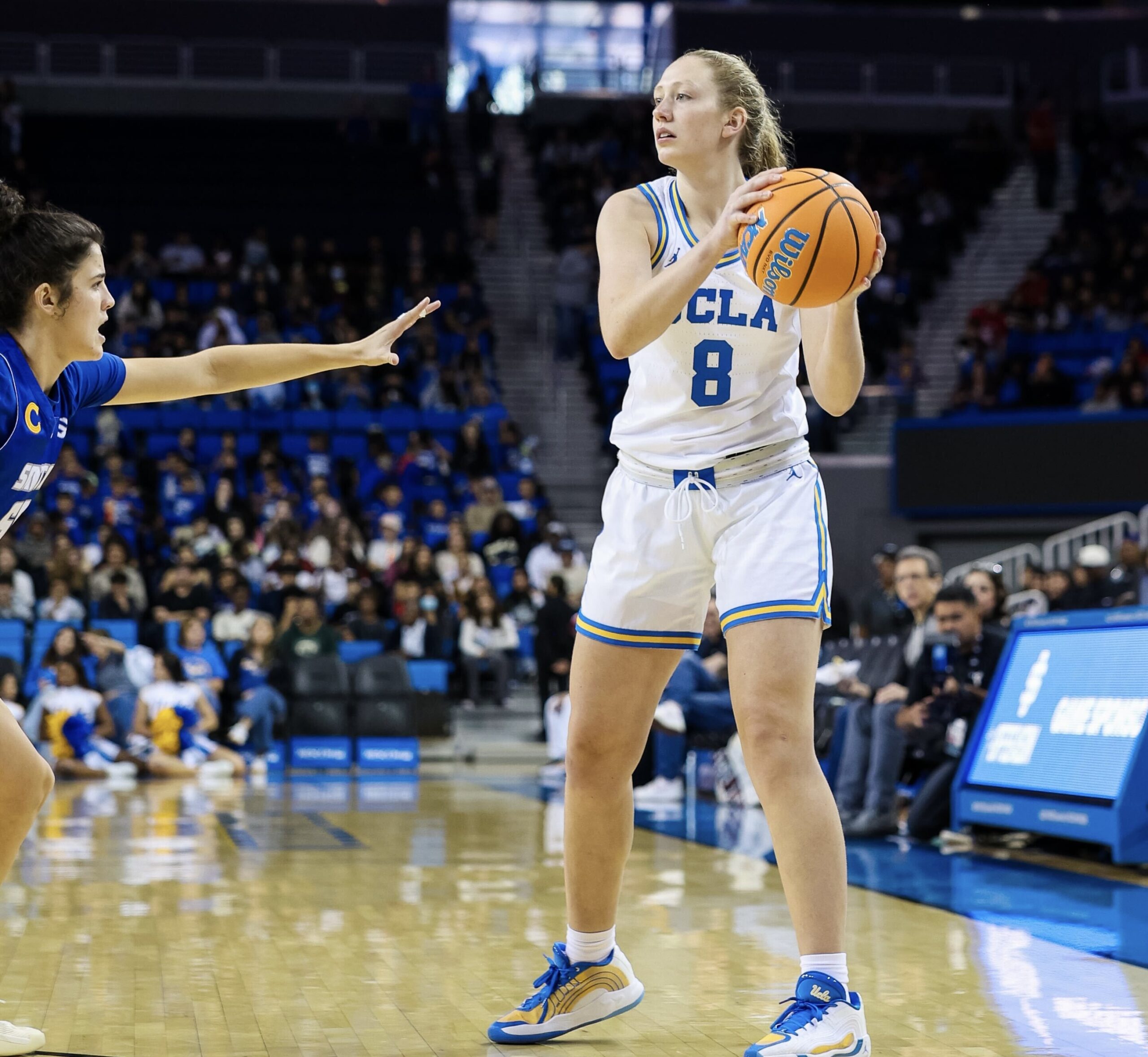 UCLA guard Gianna Kneepkens looks to make a pass while being defended by UCSB guard Skylar Burke.