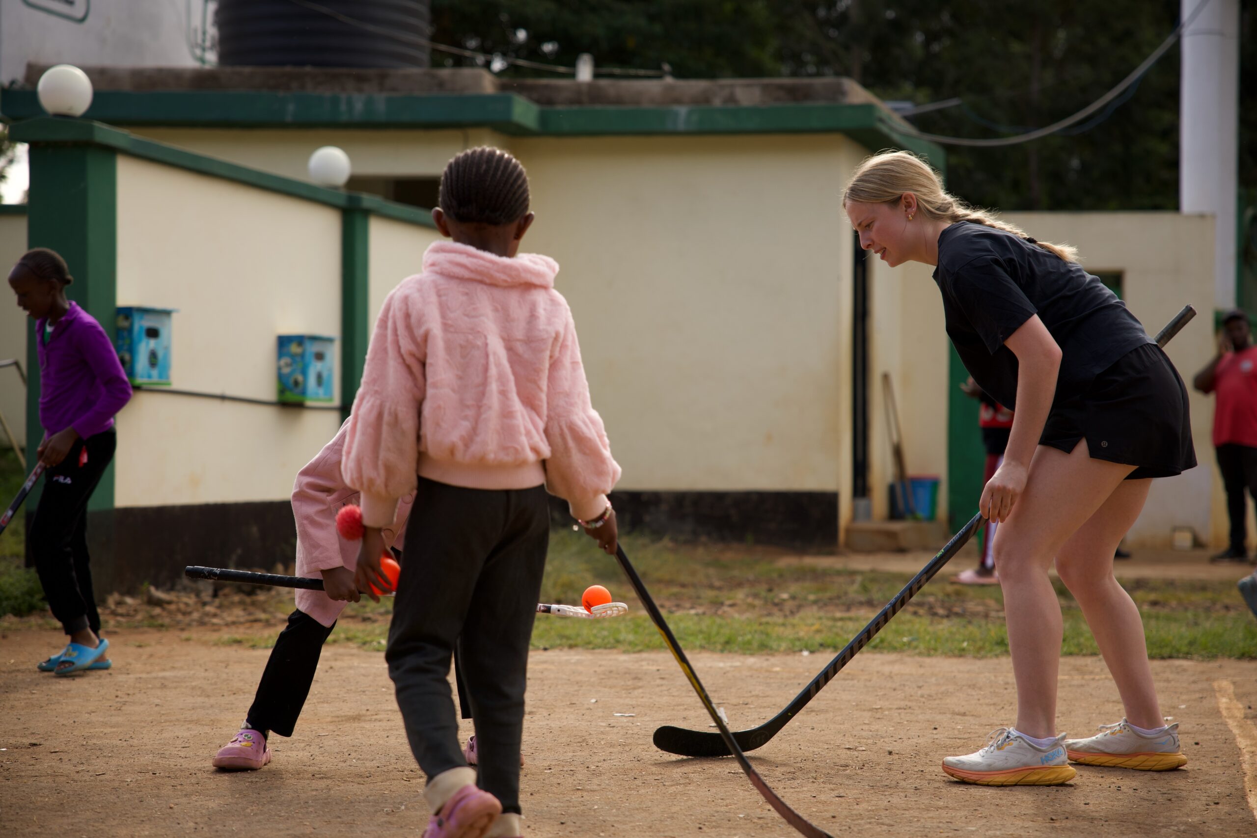 Sarah Thompson plays indoor floor hockey with two kids