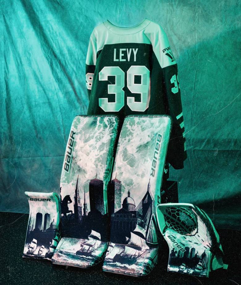 Levy's blocker, leg pads, and glove. Parts of Boston skyline are drawn on them, with ships sailing along the bottom. One of the pads and the glove also features Paul Revere's silhouette.