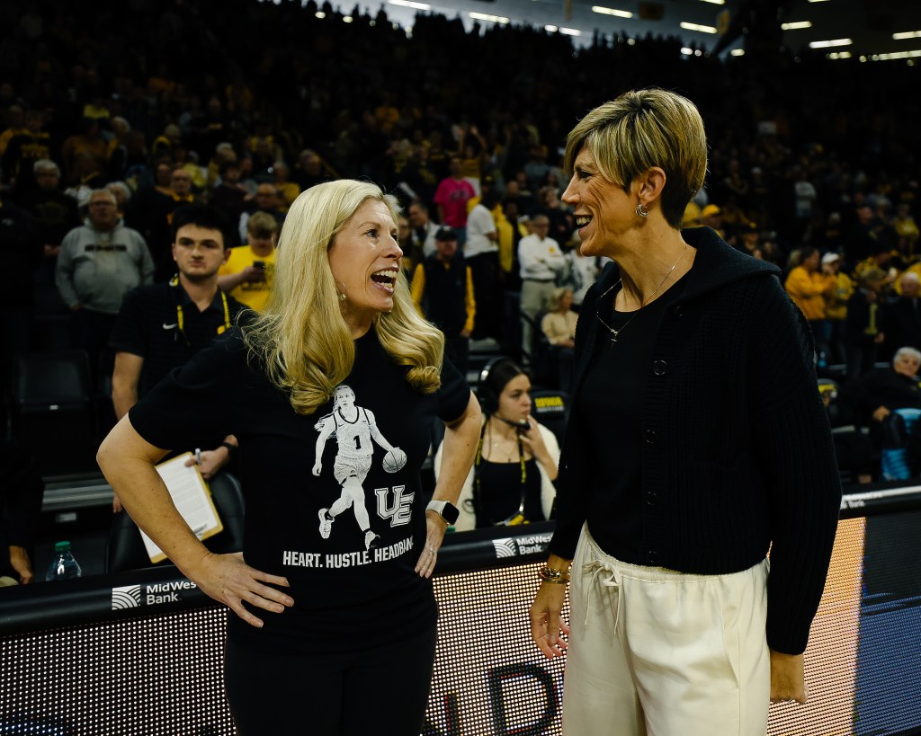 Evansville head coach Robyn Scherr and Iowa head coach Jan Jensen share a laugh before the their game in Iowa City, Iowa.