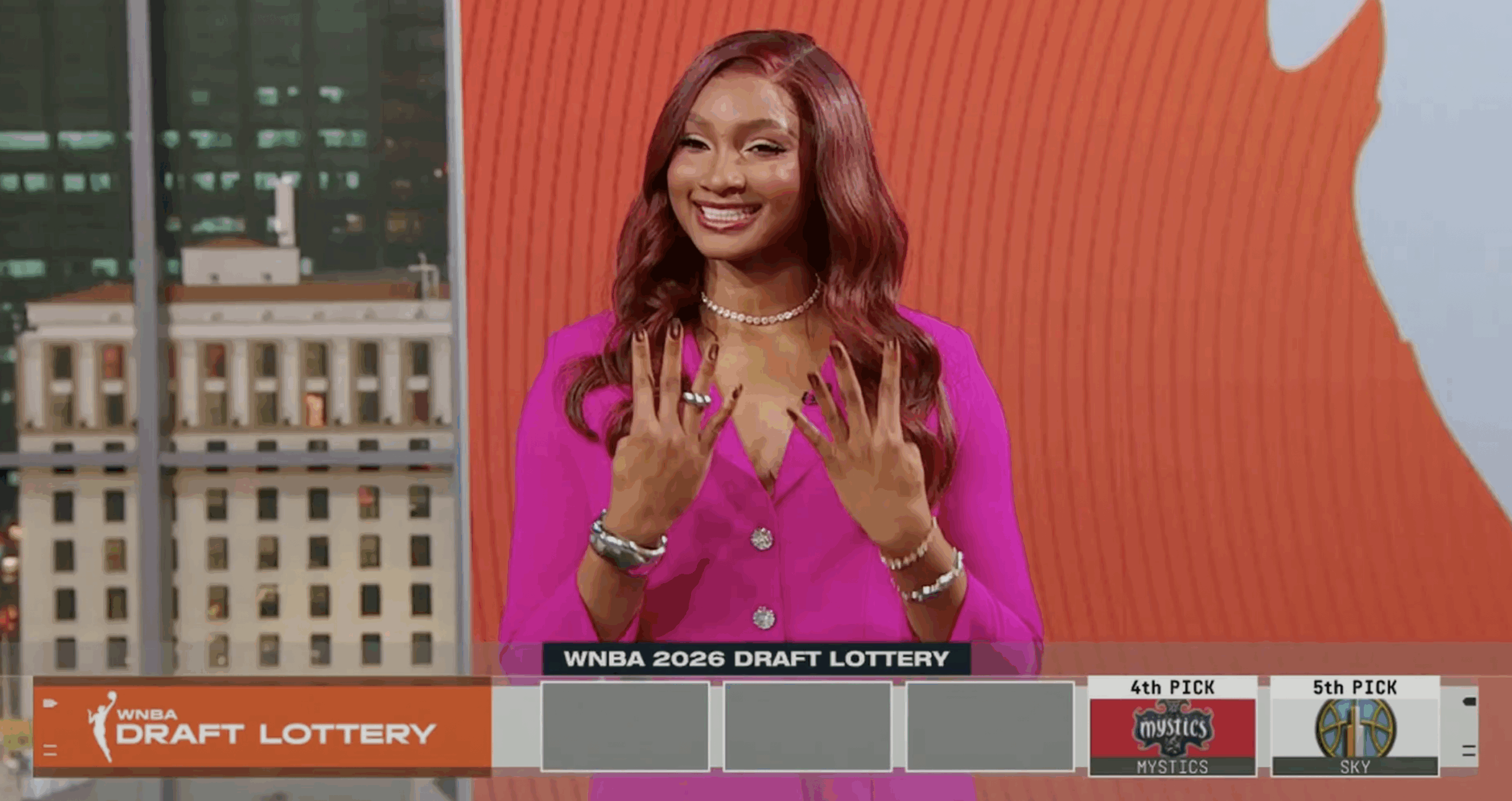 Washington Mystics forward Kiki Iriafen smiles and holds up four fingers on each hand in response to Washington getting the fourth overall pick in the 2026 WNBA Draft. She is shown on the broadcast of the draft lottery, and a graphic with the lottery results is overlaid at the bottom.