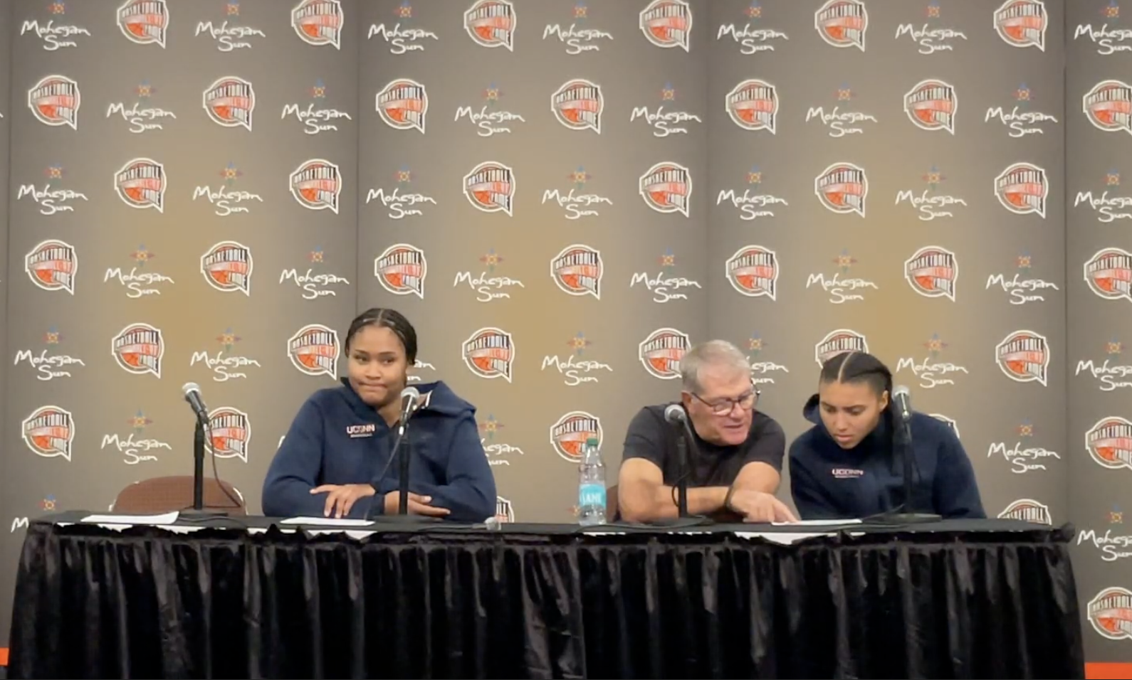 Sarah Strong speaks, Geno Auriemma and Azzi Fudd marvel.