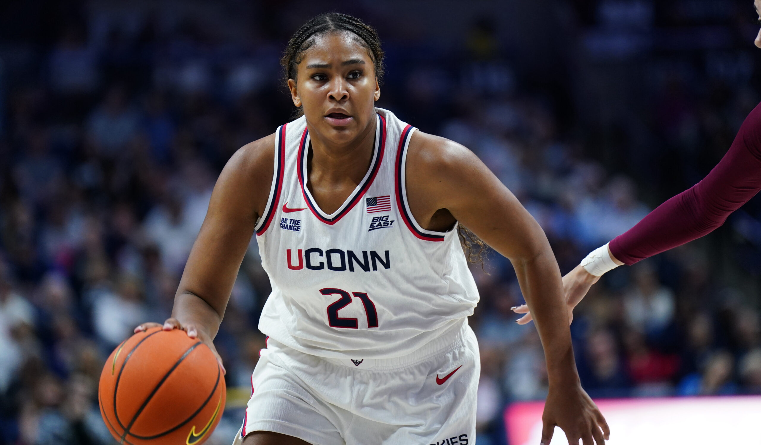 UConn forward Sarah Strong, wearing UConn's home white jersey, drives to the basket with the ball in her right hand