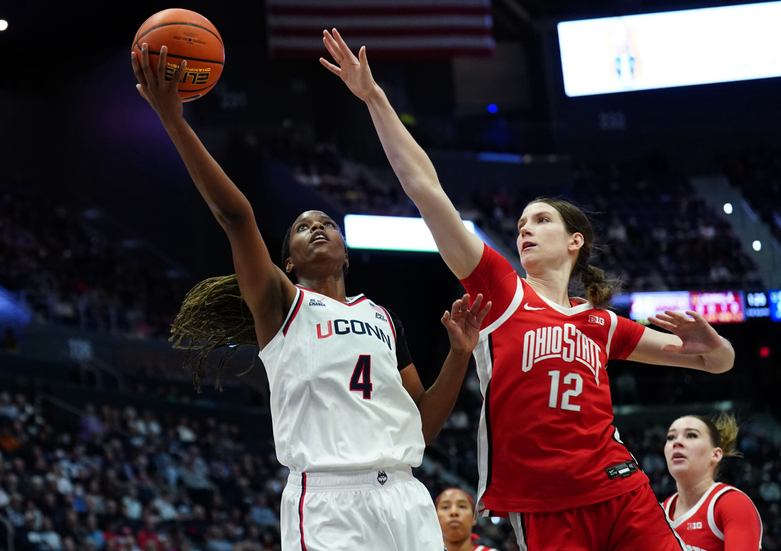 UConn guard Blanca Quiñonez drives with her right hand to the basket and extends her arm to try to shoot. Ohio State center Elsa Lemmilä reaches with her right hand to try to block the shot.