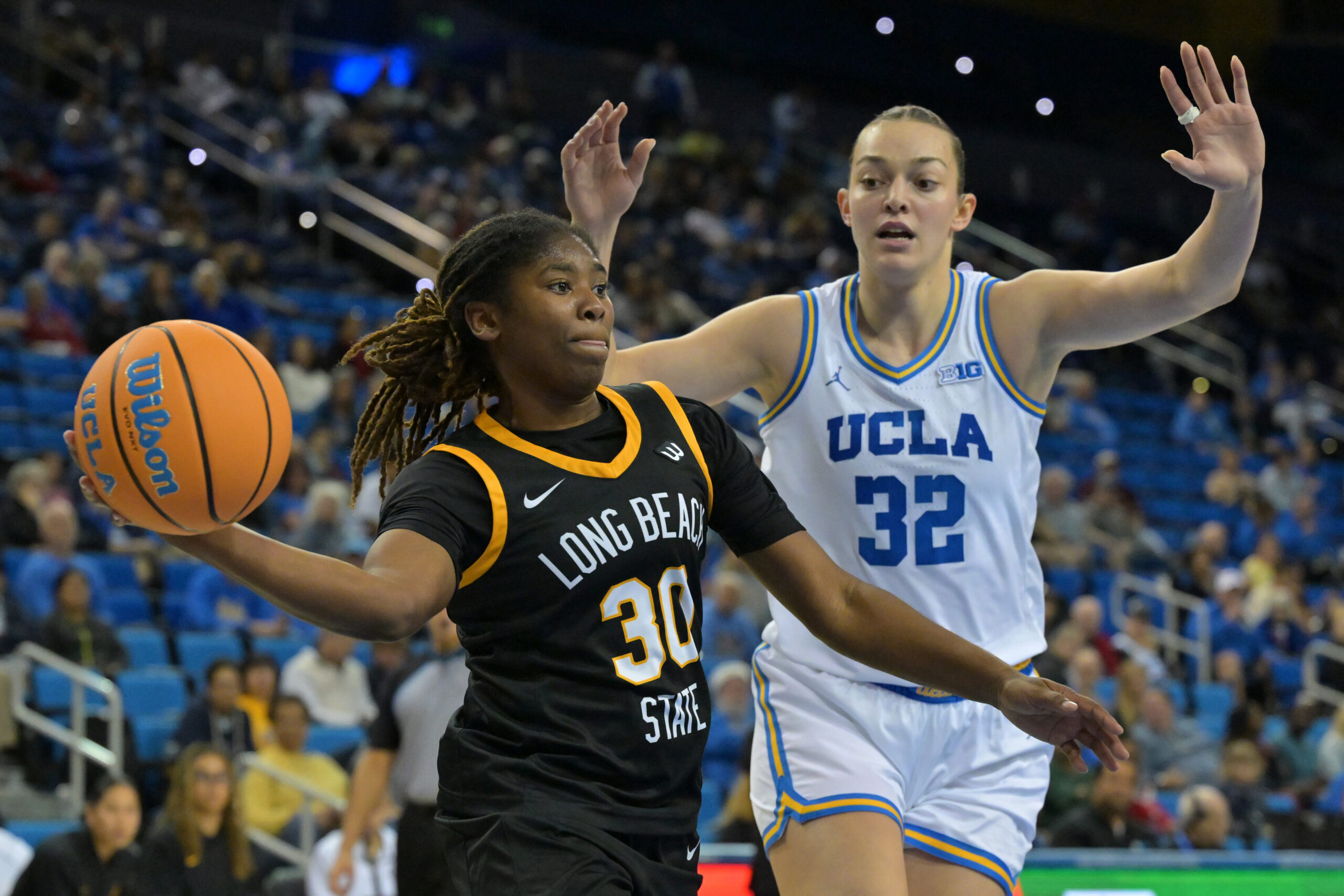 Long Beach State guard JaQuoia Jones-Brown passes the ball with UCLA forward Angela Dugalic defending
