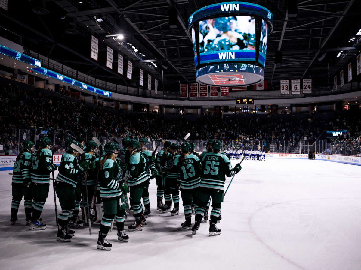 The Fleet celebrate their win with team fist bumps and hugs. They are all wearing green home uniforms.