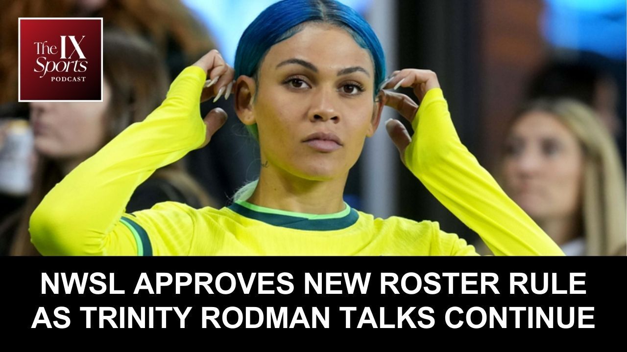 Trinity Rodman wears a yellow uniform and holds onto her hair, which is blue