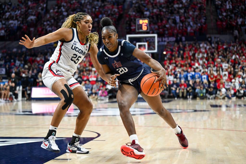 Former Fairleigh Dickinson Knights forward Teneisia Brown (20) drives to the basket towards the camera, defended by Connecticut Huskies forward Ice Brady on her right hip