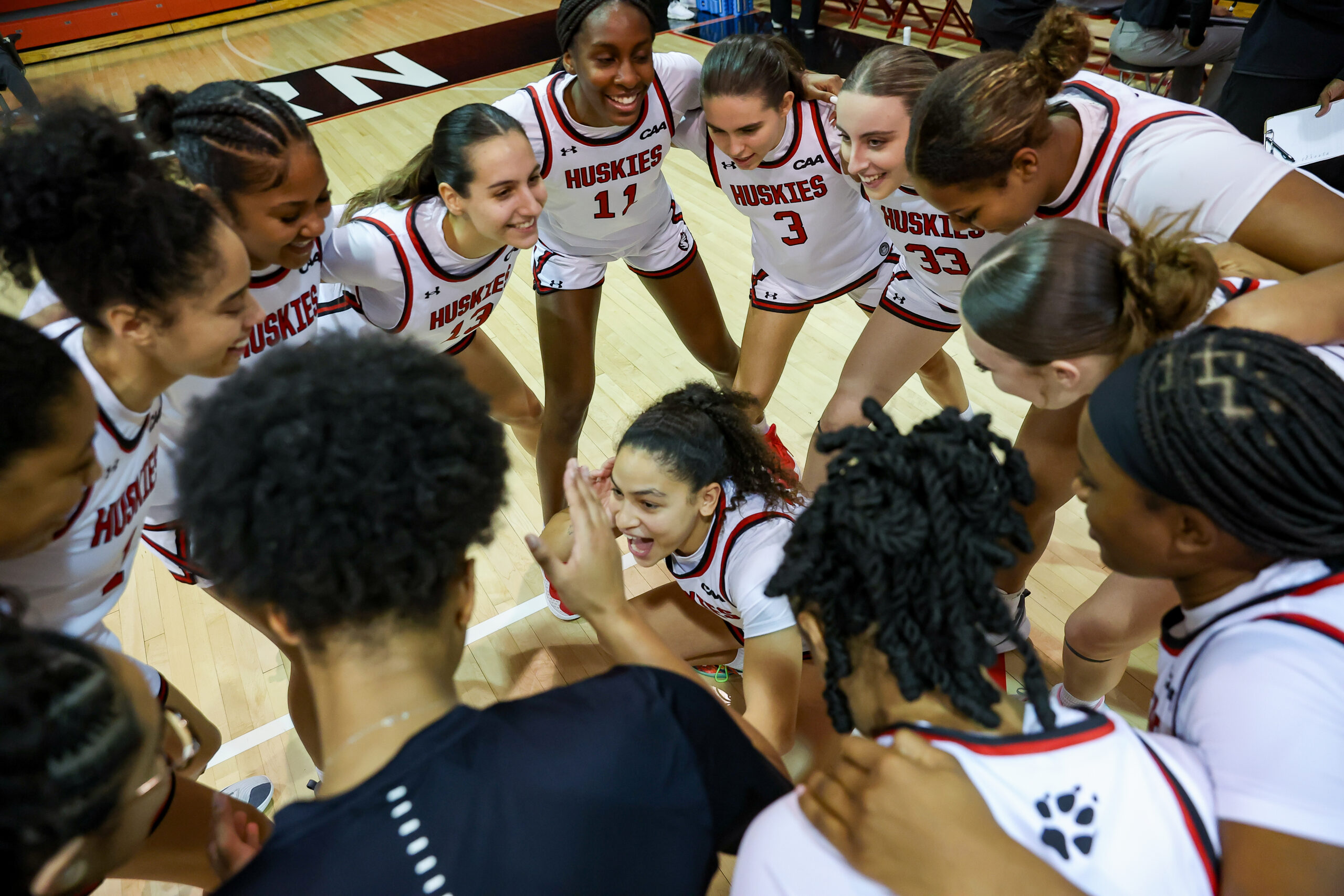 Northeastern gathers in a pregame team huddle.