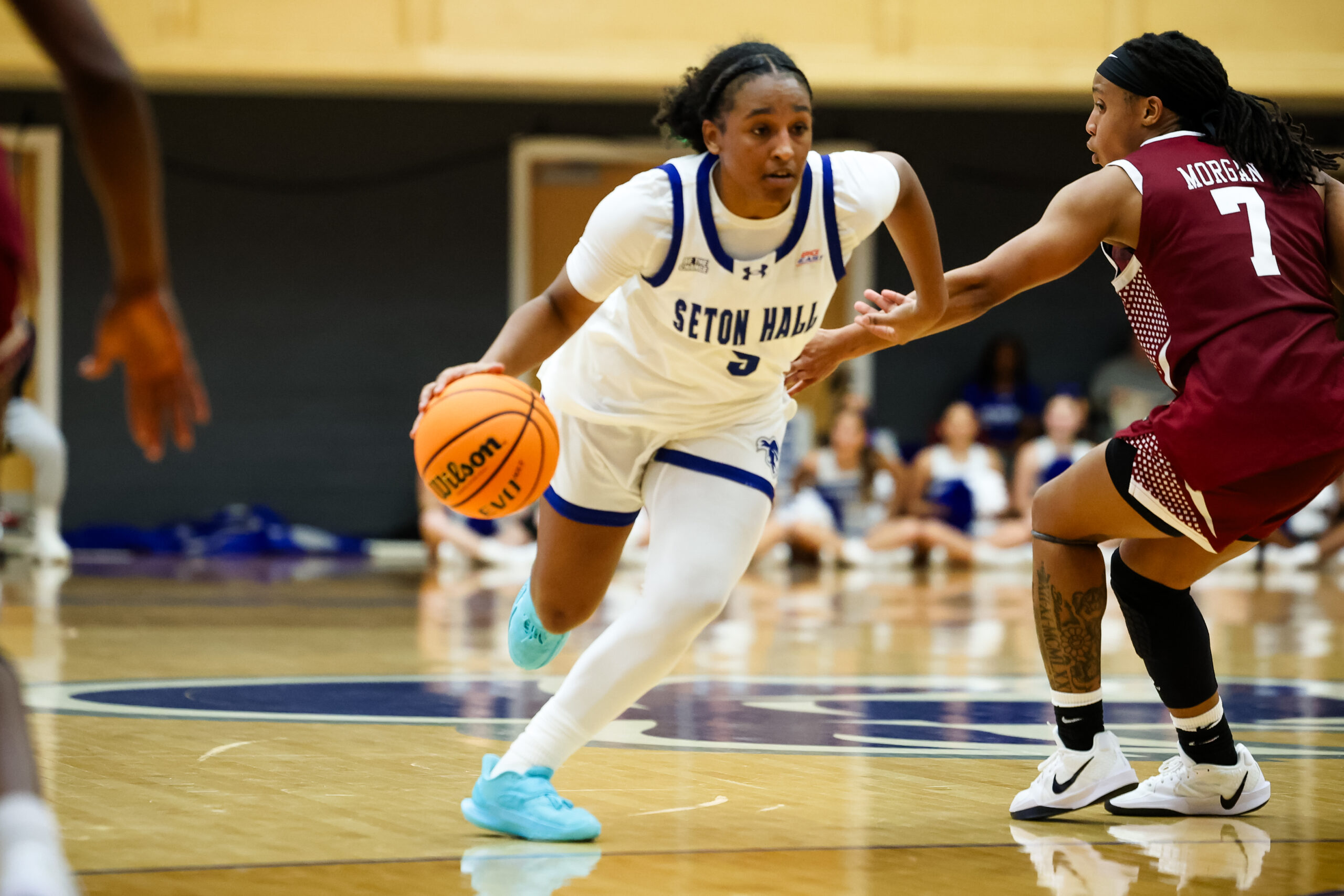 Savannah Catalon drives to the basket, wearing a home white jersey drives to the basket against a Fordham defender
