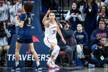 Azzi Fudd points her right index finder while running back on defense