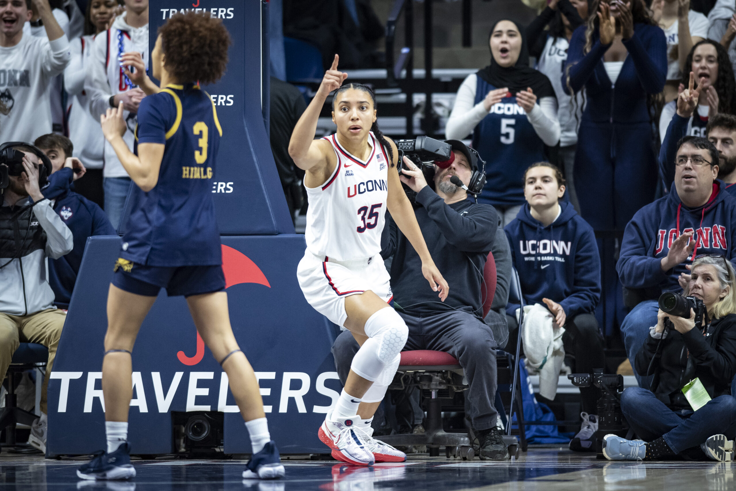 Azzi Fudd points her right index finder while running back on defense