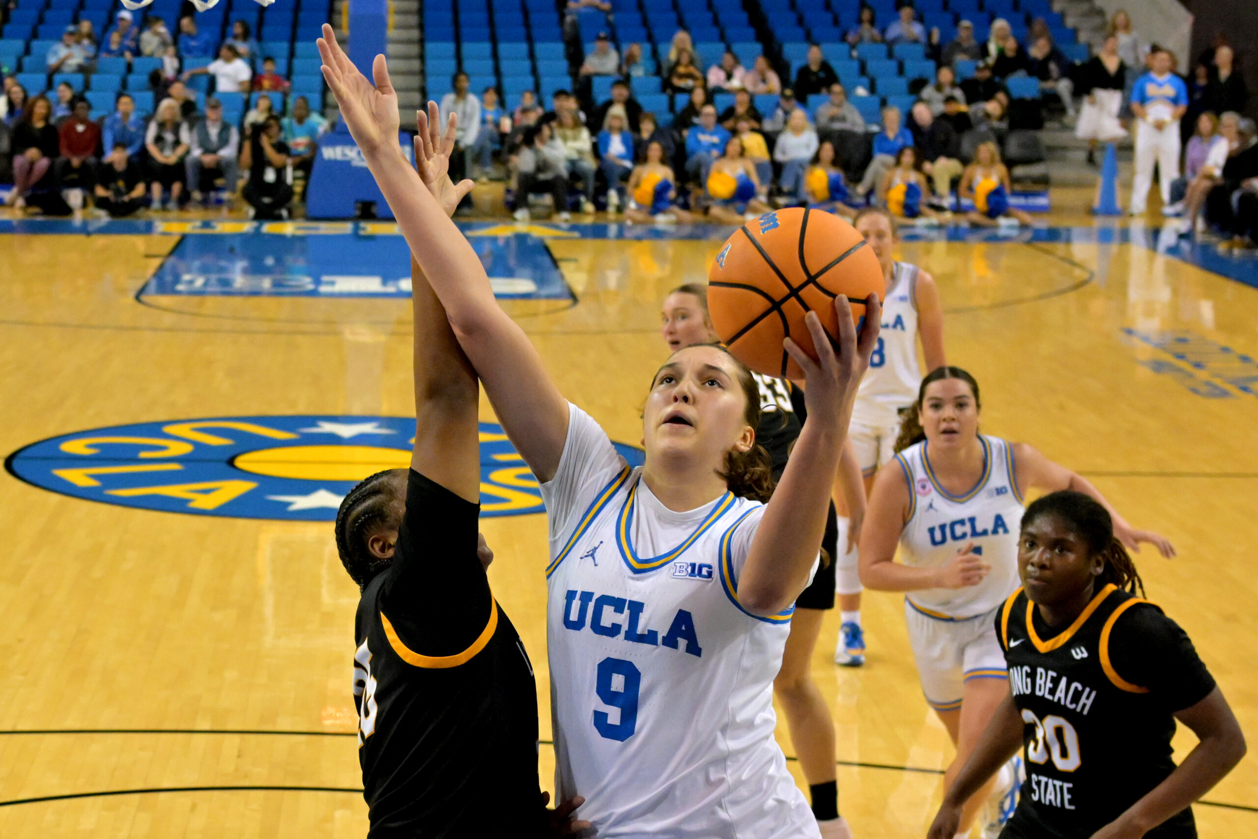 UCLA freshman guard Lena Bilic shields the ball from a LBSU defender while going up for a layup.