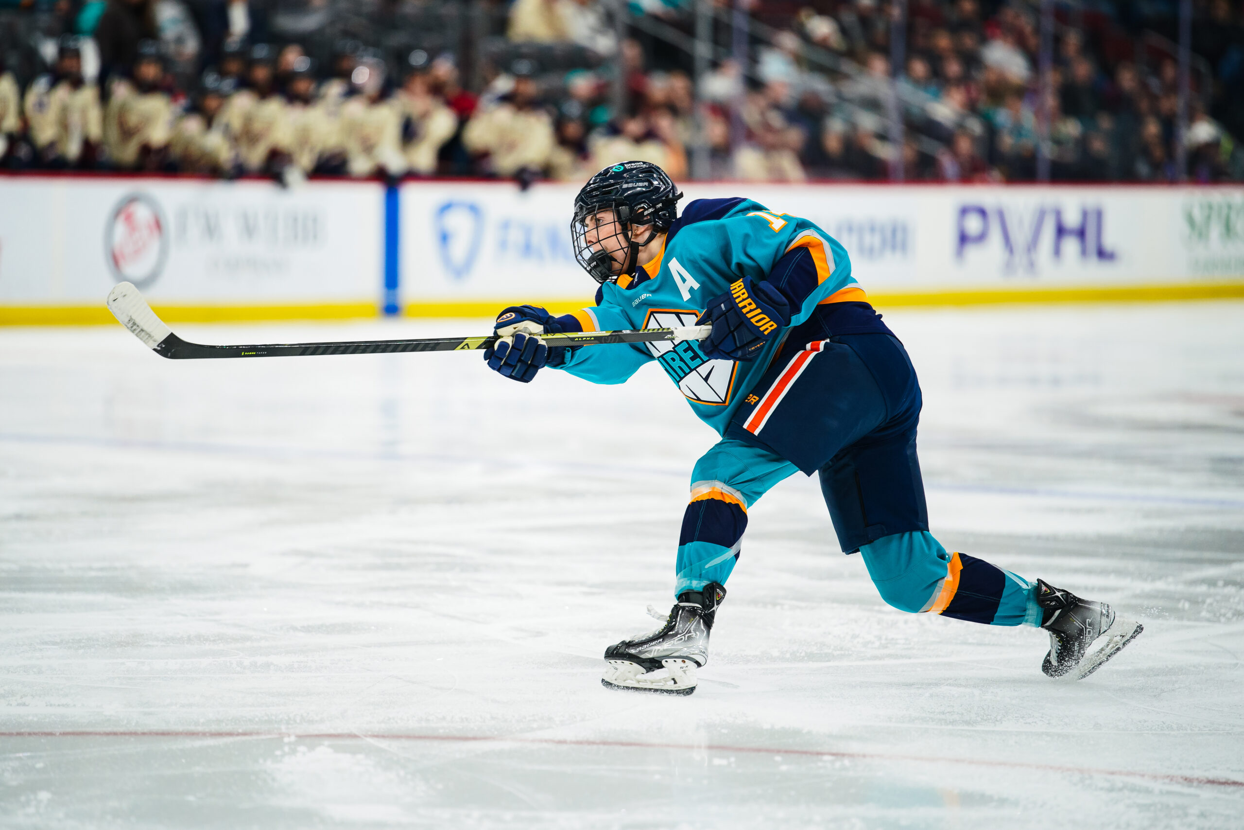 A player in a blue and black uniform skates on the ice