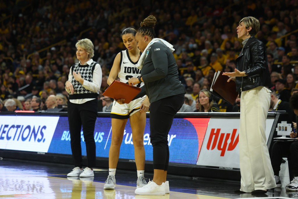 Raina Harmon talks to guard Gabbie Marshall as head coach Lisa Bluder and associate coach Jan Jensen look on at Carver-Hawkeye Arena in Iowa City, Iowa.