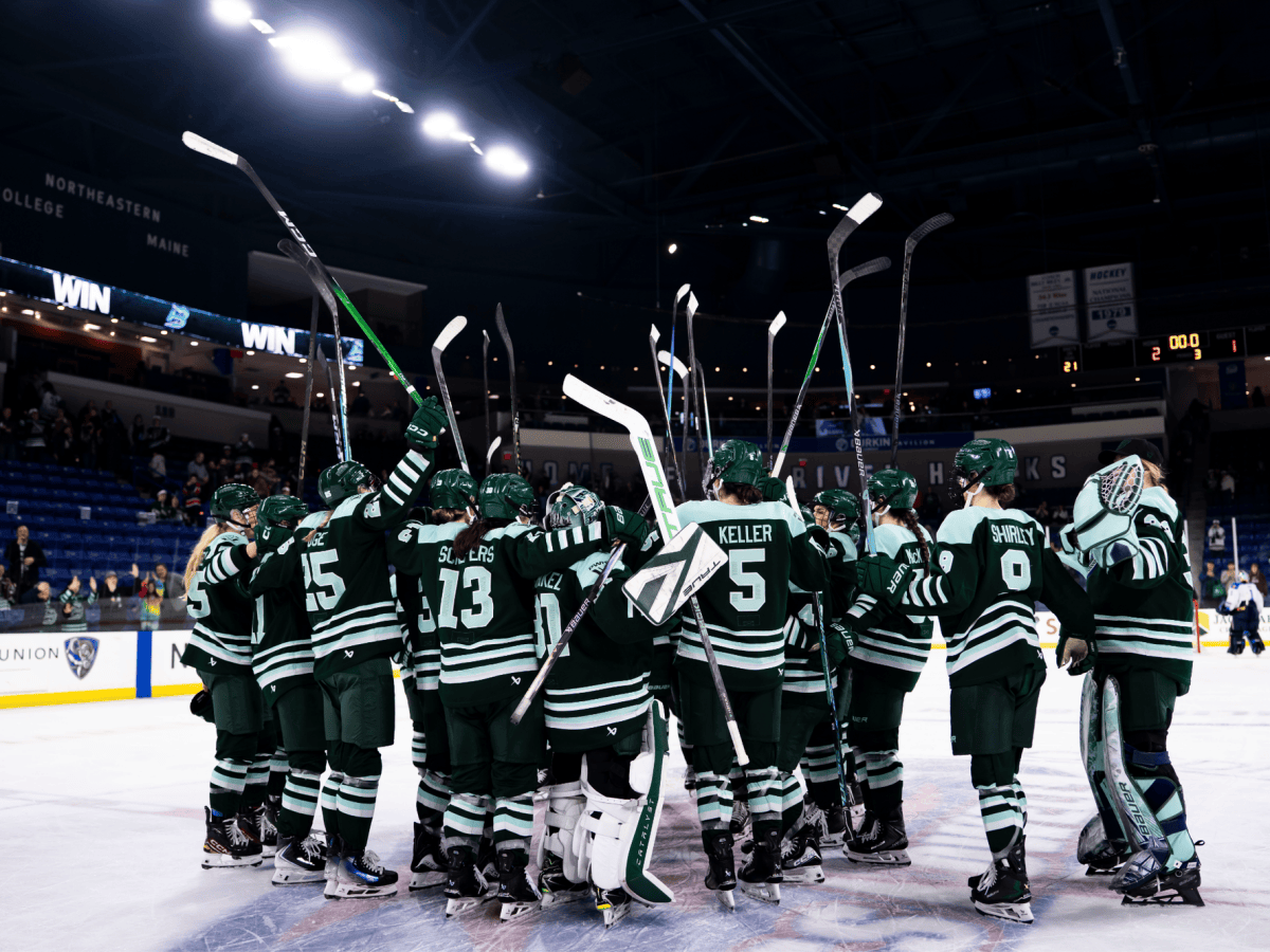 The Fleet gather at center ice to salute the crowd hug and partake in a whole group hug. They are all wearing green home uniforms.