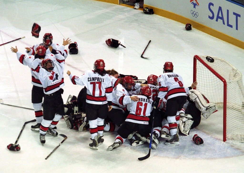 Team Canada celebrates by piling near their goal after winning gold in women's ice hockey during the 2002 Winter Olypics.