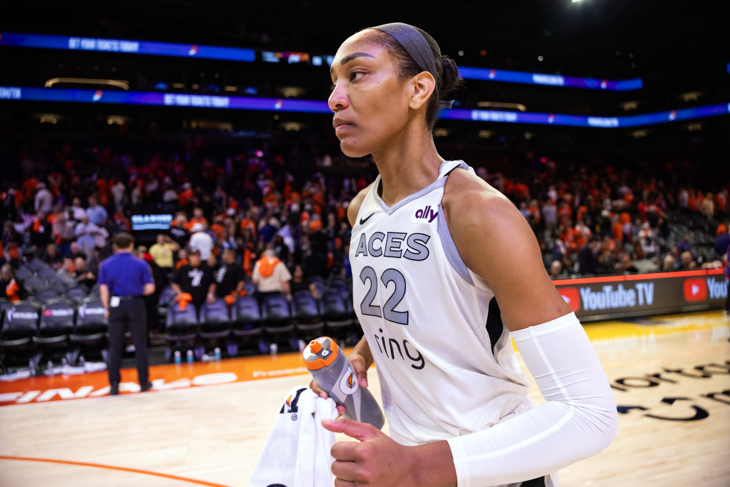A'ja Wilson stands on a basketball court in a white jersey