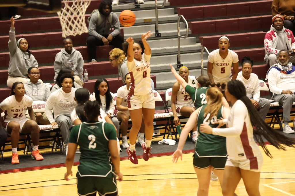 North Carolina Central's Aysia Hinton releases her record-setting 11th 3-pointer in a game against William Peace and players on the bench cheer.